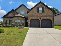 Charming two-story brick home with a well-manicured lawn and two-car garage at 1750 Stone Meadow Rd, Lithonia, GA 30058