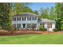Charming two-story home with a well-manicured lawn and a classic facade with black shutters at 1953 Windcrest Sw Dr, Lilburn, GA 30047