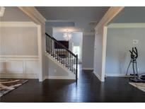 Spacious entryway featuring hardwood floors, staircase, and decorative chandelier leading into the living spaces at 552 Warrenton Run Dr, Sugar Hill, GA 30518