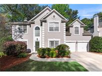Charming stucco two-story home with a well-manicured lawn and two-car garage at 1035 Bridle Path Dr, Lawrenceville, GA 30045