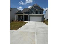Charming two-story home featuring a well-manicured lawn and a spacious driveway at 233 Bloomfield Cir, Canton, GA 30114