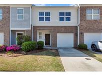 Charming townhome with brick facade, attached garage, and well-maintained landscaping at 1929 Millstream Holw, Conyers, GA 30012