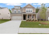 Inviting two-story brick home featuring a well-manicured lawn and an attached two-car garage at 6100 Marigold Way, Atlanta, GA 30349