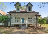 Charming home with a covered front porch, white siding, and a well-manicured lawn at 280 Old Carrollton Rd, Carrollton, GA 30116