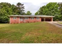 Charming one story brick home with attached carport and well-manicured lawn at 3556 Forest Hill Rd, Powder Springs, GA 30127