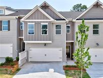 Charming townhome featuring gray brick, a two-car garage and a well-manicured front yard at 1217 Fern Ridge Ct # 16, Norcross, GA 30093