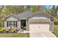 Charming single-Gathering home featuring a well-manicured lawn, attached garage and a welcoming front porch at 173 Bramlett Ridge Dr, Dallas, GA 30157
