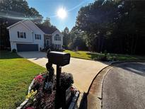 Charming two-story home featuring manicured front lawn, inviting curb appeal, and attached two car garage at 3927 Villager Way, Rex, GA 30273