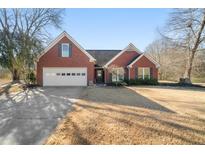 Charming brick home featuring a two-car garage and well-maintained front yard at 7430 Valley Landing Ct, Cumming, GA 30041