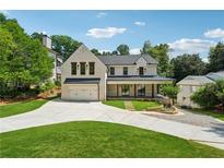 Stunning two-story home featuring a brick exterior, covered porch, and meticulously landscaped front yard at 819 Loridans Ne Dr, Atlanta, GA 30342