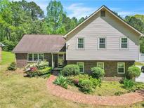 Charming home featuring brick accents, a manicured lawn, and a delightful brick walkway at 9082 Chestnut Lake Dr, Jonesboro, GA 30236