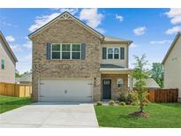 Charming two-story brick home featuring an attached garage and a well-manicured lawn at 814 Lakehaven Ln, Loganville, GA 30052