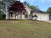 Charming home with manicured lawn, flowering trees, and attached two car garage at 9454 Lakeview Ct, Douglasville, GA 30135