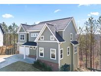 Two-story home featuring neutral siding, a dark roof, white trim, and an attached two-car garage at 3180 Tackett Rd, Douglasville, GA 30135