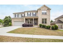 Charming two-story home with a well-manicured lawn and a mix of brick and siding at 3570 Terrasol Sw Trl, Lilburn, GA 30047