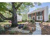 Charming brick home featuring lush landscaping and a welcoming walkway to the front door at 510 Birch Ridge Ct, Roswell, GA 30076