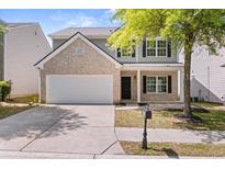 Charming two-story home featuring a brick facade, well-kept landscaping, and an attached two-car garage at 5209 Carrington Park Dr, Powder Springs, GA 30127