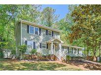 Charming two-story home with a manicured front yard and mature trees providing ample shade at 1718 Country Park Way, Lawrenceville, GA 30043