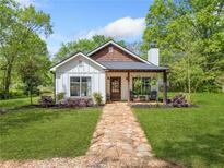 Charming home featuring a manicured lawn and inviting stone pathway to a cozy front porch at 1809 Cassville Nw Rd, Cartersville, GA 30121