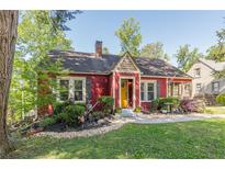 Charming red home with a well-manicured lawn, landscaping, and a welcoming yellow front door at 2733 Winburn Ter, East Point, GA 30344