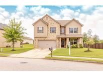 Charming two-story home with brick and siding, a well-manicured lawn, and a two-car garage at 375 Madison Grace Ave, Mcdonough, GA 30252
