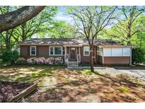 Charming single-story home with a welcoming front yard, flowerbeds and mature shade trees at 1400 Hidden Circle Dr, Sugar Hill, GA 30518