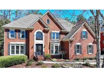 Beautiful brick home with a well-manicured front yard and black shutters on a sunny day at 210 Eden Bridge Pl, Johns Creek, GA 30022