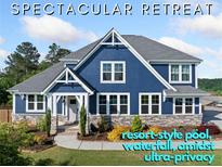 Beautiful two-story blue home featuring stone accents, white trim and lush landscaping at 2111 Harmony Dr, Canton, GA 30115