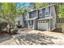 Charming two-story home with blue accents, attached garage, and mature trees surrounding the property at 2998 Kenville Ln, Decatur, GA 30034