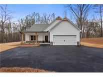 Charming new construction home with white siding, stone accents, and a spacious driveway at 1687 Harmony Rd, Temple, GA 30153