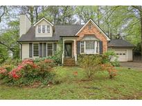 Charming home with dormer windows, black shutters, brick accent and front yard with flowering plants at 172 Forest Nw Ln, Marietta, GA 30064