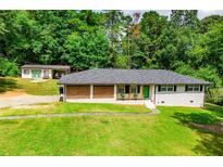 Charming single-story home featuring a bright green front door and meticulously manicured lawn at 5950 Central Church Rd, Douglasville, GA 30135