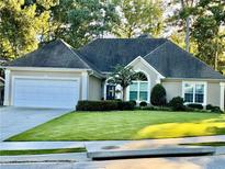 Charming single-story home with a well-manicured lawn, attached garage, and inviting curb appeal at 10825 Pinewalk Forest Cir, Alpharetta, GA 30022