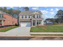 Charming two-story brick home featuring a two-car garage and manicured front lawn at 612 Leafy Branch Way, Mcdonough, GA 30253