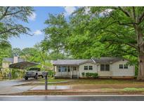 Cozy home with a large, mature tree, carport, and landscaped front yard offers curb appeal at 3024 Bob Cox Rd, Marietta, GA 30064