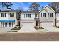 Charming townhome featuring a brick and siding facade, two-car garage, and well-manicured landscaping at 413 Brooch Way, Stockbridge, GA 30281