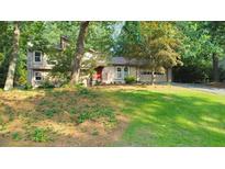 Charming multi-level home featuring a lush lawn, mature trees, and a welcoming two-car garage at 951 Woodmont Dr, Marietta, GA 30062
