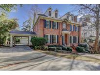 Charming two-story brick home featuring a covered carport and landscaped front yard at 55 Asheworth Ct, Atlanta, GA 30327