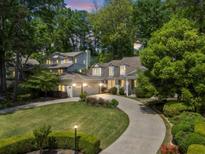Stunning exterior view of a home with a lush green lawn and a winding driveway, and a three car garage at 998 Ferncliff Ne Rd, Atlanta, GA 30324