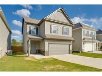 Charming two-story home featuring a gray exterior, attached garage, and well-maintained front lawn at 2316 Hastings Manor Ln, Hampton, GA 30228