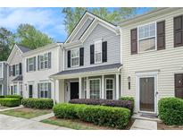 Charming townhome featuring a welcoming entrance, well-maintained landscaping, and classic architectural details at 1728 Devon Sw Dr, Atlanta, GA 30311
