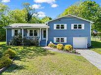 Charming blue two-story home with white trim, manicured lawn, and a welcoming front porch at 363 Arnold Mill Rd, Woodstock, GA 30188
