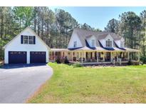 Charming two-story farmhouse featuring a welcoming front porch and two-car garage at 377 Lakeview Dr, Newborn, GA 30056
