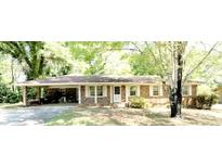 Charming single-story brick home with a welcoming carport and a well-maintained front yard at 811 Verde Dr, Riverdale, GA 30274