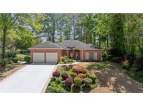 Charming brick home with a two-car garage, lush landscaping and a well-manicured lawn at 12260 Greenmont Walk, Alpharetta, GA 30009