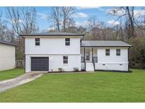 Charming two-story home with a freshly painted white exterior and well-manicured lawn at 9148 Homewood Dr, Riverdale, GA 30274