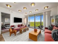 Bright living room with hardwood floors, contemporary furniture, and floor-to-ceiling windows with scenic views at 2233 Peachtree Ne Rd # 1207, Atlanta, GA 30309
