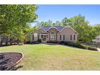 Charming home boasts a well-manicured lawn, complemented by mature trees and a stone facade entrance at 840 Whitby Dr, Douglasville, GA 30134