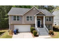 Charming two-story home with a well-manicured lawn and a welcoming front porch with gray-painted stairs at 4175 Round Stone Dr, Snellville, GA 30039