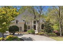 Elegant two-story home featuring a circular driveway, lush landscaping and well-maintained lawn at 960 Tiverton Ln, Alpharetta, GA 30022
